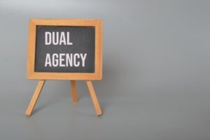 The words "Dual Agency" printed on a blackboard easel.