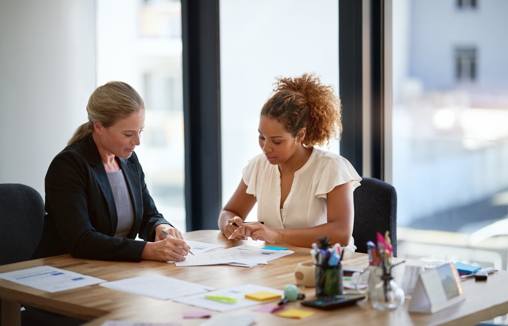 A lawyer reviewing the top reasons dentists lose their professional licenses with a client.