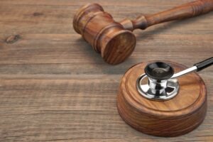 A stethoscope on top of a gavel representing how a lawyer will help in your medical license defense case.