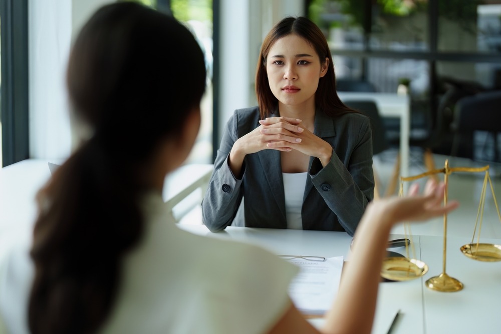 A woman sits at her lawyer’s desk and asks her, “Can you get an insurance license with a felony in Texas?”